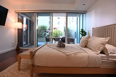 a bedroom with a bed with a teddy bear on it at The W Hotel Residence With Roof Top Pool, Gym Plus 2 Free Valet Parking spaces in Los Angeles