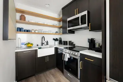 a kitchen with black cabinets and a microwave at Malibu Breeze in Malibu Beach