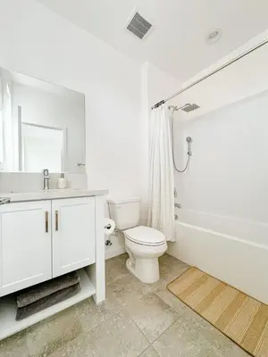 a white bathroom with a toilet and a tub and a sink at Central, Urban Townhouse with Private Roof Deck in Garden Grove