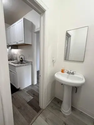 a white bathroom with a sink and a mirror at Westlake MacArthur Park Studio in Los Angeles