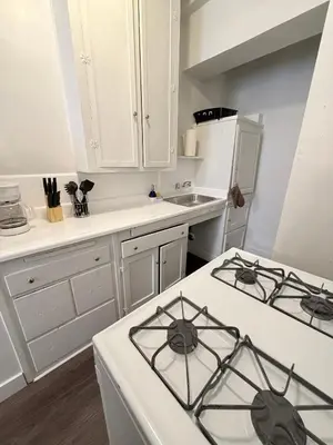 a kitchen with white cabinets and a white stove top oven at Wilshire Center K-Town Studio in Los Angeles