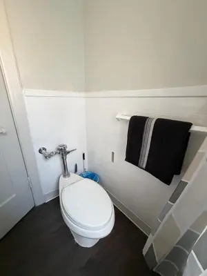 a bathroom with a toilet and a black towel at Wilshire Center K-Town Studio in Los Angeles