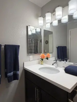 a bathroom with a sink and a mirror and blue towels at Steps from The Hollywood Walk of Fame in Los Angeles