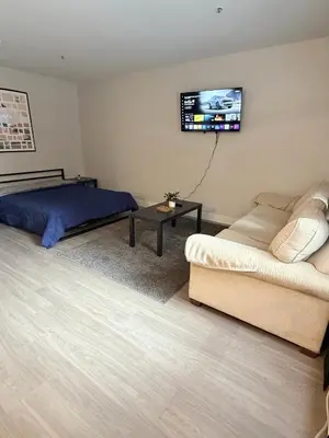 a bedroom with a bed and a couch and a flat screen tv at Steps from The Hollywood Walk of Fame in Los Angeles