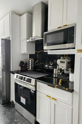 a kitchen with white cabinets and a stove and microwave at Kenmore relax in Los Angeles