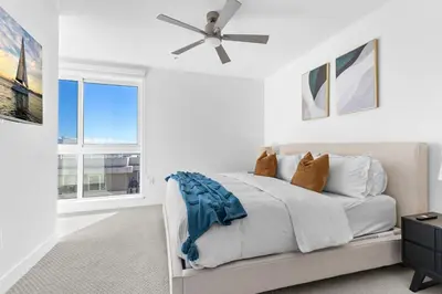 a white bedroom with a bed and a ceiling fan at Amethyst Sky Loft - Elevated Two-Story Waterfront in Los Angeles