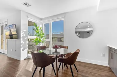 a dining room with a glass table and chairs at Amethyst Sky Loft - Elevated Two-Story Waterfront in Los Angeles