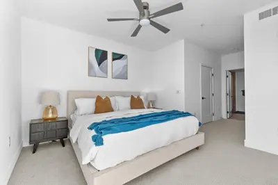 a white bedroom with a bed and a ceiling fan at Amethyst Sky Loft - Elevated Two-Story Waterfront in Los Angeles