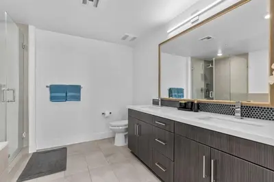 a bathroom with a sink and a toilet and a mirror at Amethyst Sky Loft - Elevated Two-Story Waterfront in Los Angeles