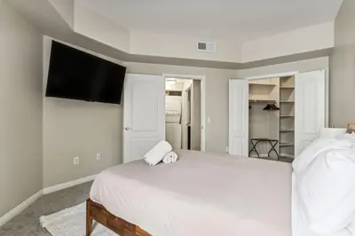 a bedroom with a white bed and a flat screen tv at Chic Marina Oasis 5 star Amenities Central in Los Angeles