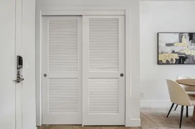 a pair of white closet doors in a room at Modern Marina Sanctuary Central Pool Gym Spa in Los Angeles