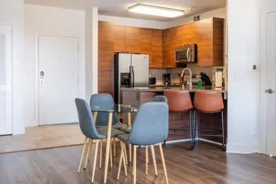 a kitchen with a table and chairs and a refrigerator at Sleek Marina Den Central Gym Pool King Bed in Los Angeles