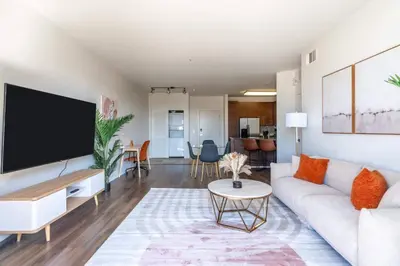 a living room with a white couch and a flat screen tv at Sleek Marina Den Central Gym Pool King Bed in Los Angeles