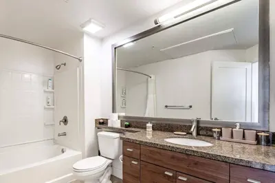 a bathroom with a sink and a toilet and a mirror at Sleek Marina Den Central Gym Pool King Bed in Los Angeles