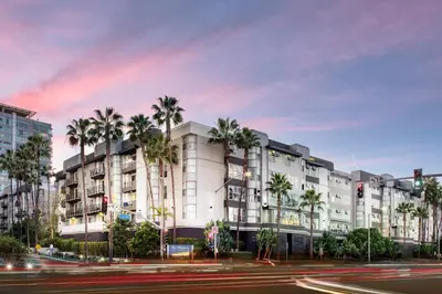 a building with palm trees in front of a street at Daybreak MDR in Los Angeles