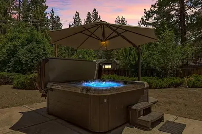 a hot tub with an umbrella in a yard at Skiers Crest - Hot Tub, Yard, Near Lake & Slopes in Big Bear Lake