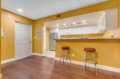 a kitchen with yellow walls and two bar stools at 2 Bed Apartment with Private Terrace Near SoFi in Los Angeles