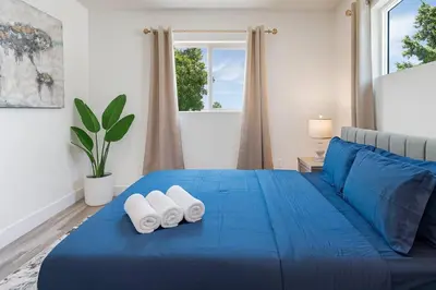 a blue bed with two white towels on it at The Harvard Modern Retreat LA in Los Angeles
