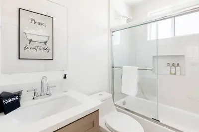 a white bathroom with a sink and a toilet at The Harvard Modern Retreat LA in Los Angeles