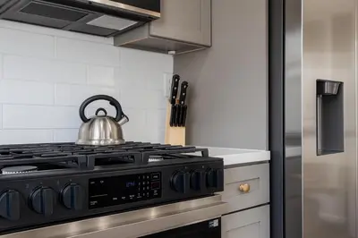 a kitchen with a stove with a tea kettle on it at The Harvard Modern Retreat LA in Los Angeles