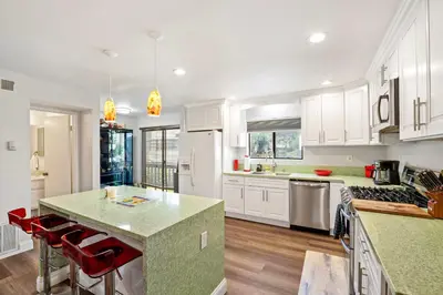 a kitchen with white cabinets and a green counter top at Elsa House in Warner Center Plaza One Heliport