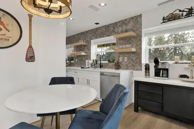 a kitchen with a white table and blue chairs at Stairway to Heaven at Big Bear- Million Dollar Lake Views - Modern Luxury Chalet w/ Hot Tub in Big Bear Lake