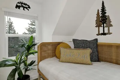 a bed with pillows and a plant in a room at Stairway to Heaven at Big Bear- Million Dollar Lake Views - Modern Luxury Chalet w/ Hot Tub in Big Bear Lake
