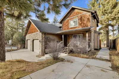 a brick house with a garage and a driveway at Brownie Resort Your Walk-to-Summit Getaway Family's Snowboarders Skiers in Big Bear Lake