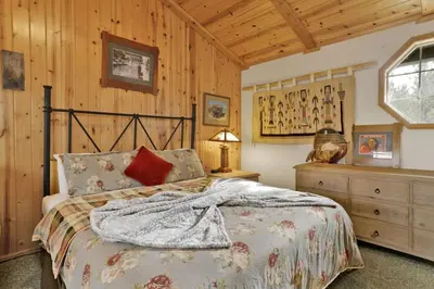 a bedroom with a bed and a wooden wall at Brownie Retreat Walk-to-Summit Mountain Getaway for Snowboarders & Skiers in Big Bear Lake