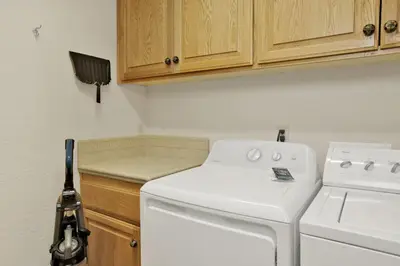 a kitchen with a stove and a white washer at Brownie Retreat Walk-to-Summit Mountain Getaway for Snowboarders & Skiers in Big Bear Lake