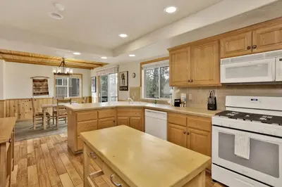 a kitchen with wooden cabinets and white appliances at Brownie Retreat Walk-to-Summit Mountain Getaway for Snowboarders & Skiers in Big Bear Lake
