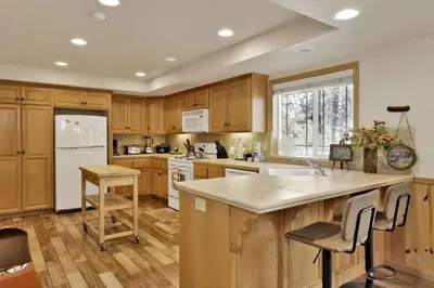 a kitchen with wooden cabinets and a white refrigerator at Brownie Resort Retreat Walk-to-Ski Snow Summit Duplex Getaway in Big Bear Lake