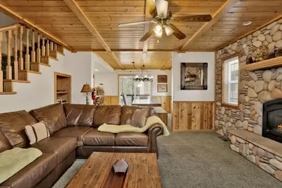 a living room with a leather couch and a fireplace at Brownie Resort Retreat Walk-to-Ski Snow Summit Duplex Getaway in Big Bear Lake