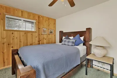 a bedroom with a bed and a table with a lamp at Brownie Resort Retreat Walk-to-Ski Snow Summit Duplex Getaway in Big Bear Lake