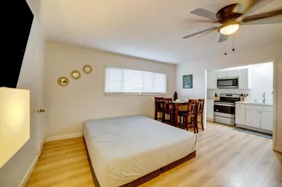 a bedroom with a bed and a kitchen with a ceiling fan at Work and Play! Studio 7 Mi to Dtwn San Bernardino in Rialto