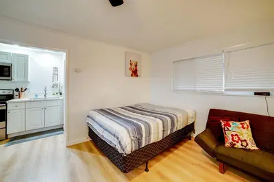 a bedroom with a bed and a couch and a kitchen at Work and Play! Studio 7 Mi to Dtwn San Bernardino in Rialto