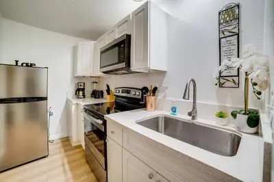 a kitchen with a sink and a stainless steel refrigerator at Work and Play! Studio 7 Mi to Dtwn San Bernardino in Rialto