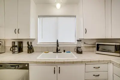 a white kitchen with a sink and a window at Home 1 Mi to UC Riverside Families Welcome! in Riverside