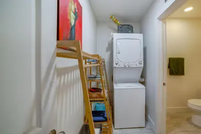 a laundry room with a refrigerator and a ladder at 5 Mi to Dtwn Riverside and Hospital! Remote-Work Hub in Riverside