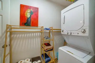 a white refrigerator in a kitchen with a painting on the wall at 5 Mi to Dtwn Riverside and Hospital! Remote-Work Hub in Riverside