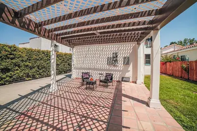 a patio with two chairs under a wooden pergola at Fully Furnished 1-Bedroom in Los Angeles