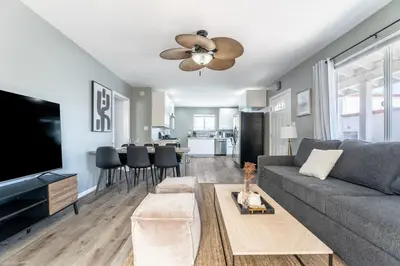 a living room with a gray couch and a ceiling fan at Hawthorne Haven Spacious 4BR Retreat in Hawthorne