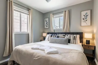 a bedroom with a large bed with two towels on it at Hawthorne Haven Spacious 4BR Retreat in Hawthorne