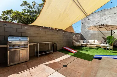 a patio with a grill and an umbrella at Hawthorne Haven Spacious 4BR Retreat in Hawthorne