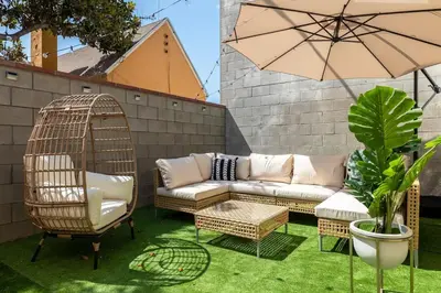 a patio with a couch and chairs and an umbrella at Hawthorne Haven Spacious 4BR Retreat in Hawthorne