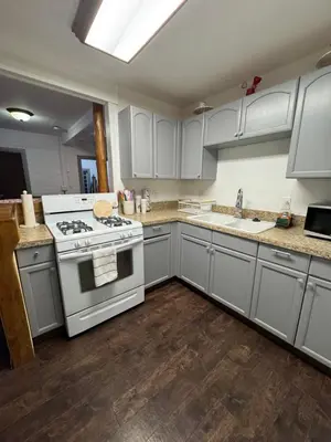 a kitchen with white cabinets and a stove at Snuggle Inn Cabin in Running Springs