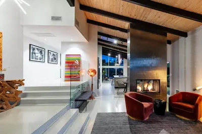 a living room with a fireplace and red chairs at Hillside Luxury MidCentury Modern Spa Retreat View in Los Angeles