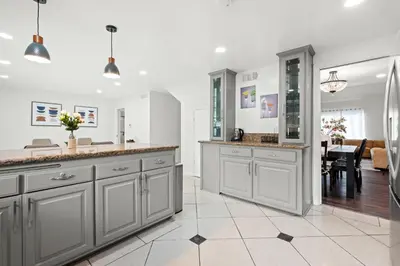 a kitchen with gray cabinets and a dining room at Cozy Full Bedroom Shared Home Great Value in Norwalk