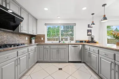 a kitchen with gray cabinets and a large window at Cozy Full Bedroom Shared Home Great Value in Norwalk