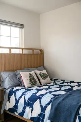 a bed with a blue and white comforter and a window at Cozy Full Suite Private Bathroom Quiet Stay in Norwalk